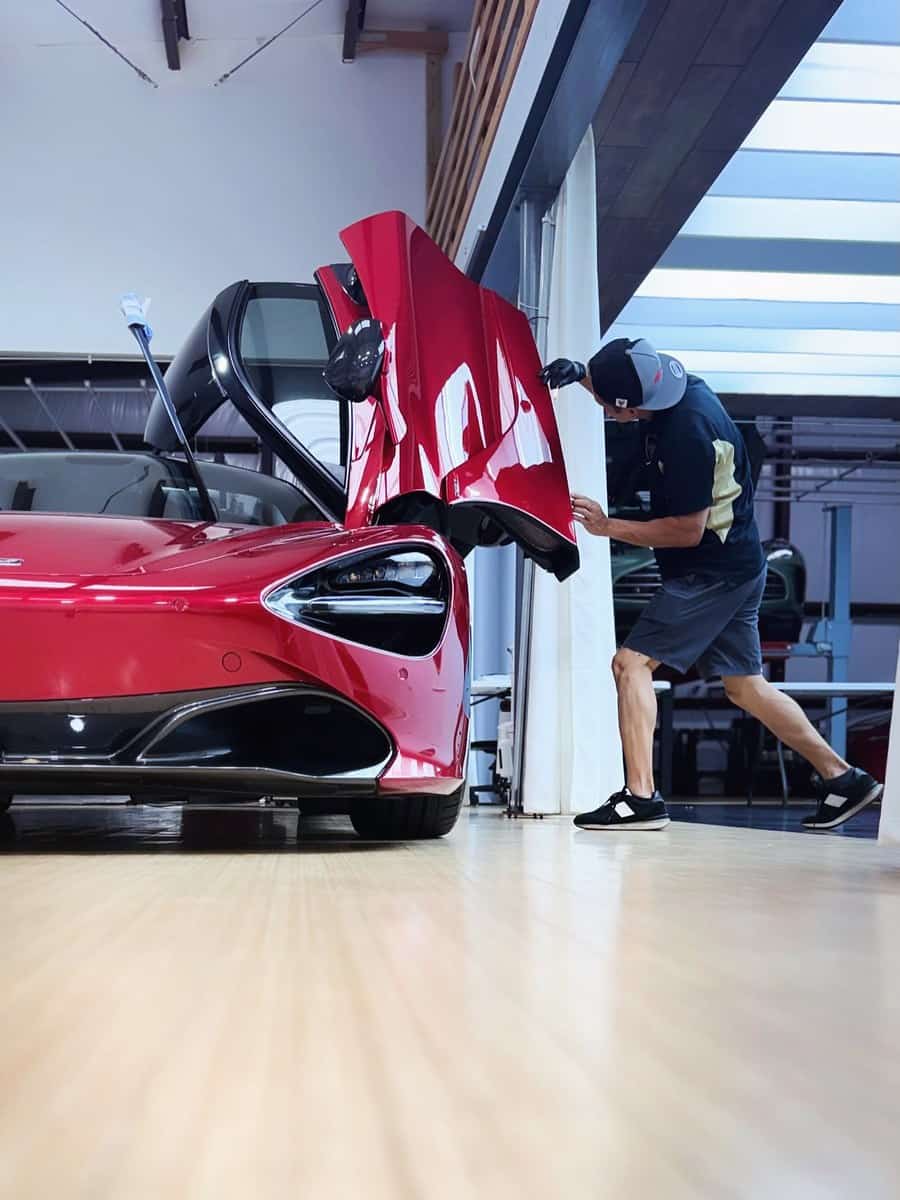 Red McLaren 720S with doors raised in the workshop