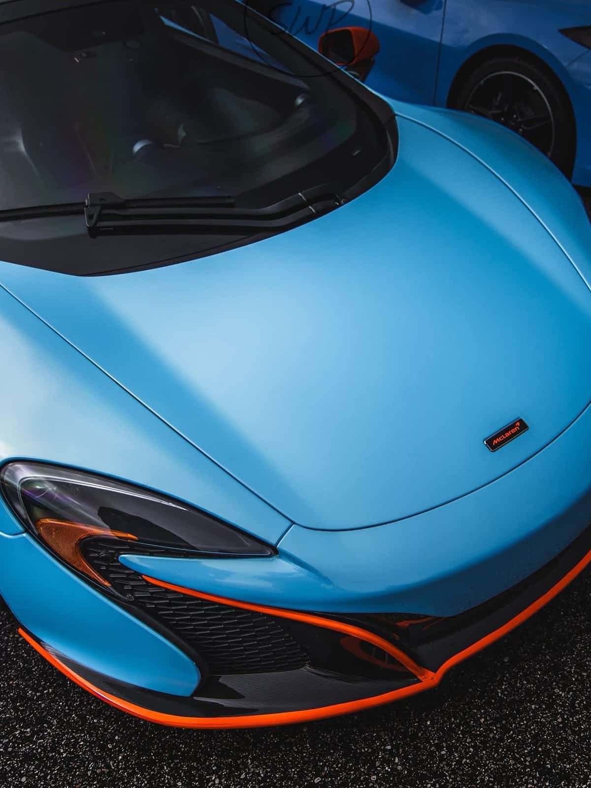 Baby-blue McLaren under a storm sky