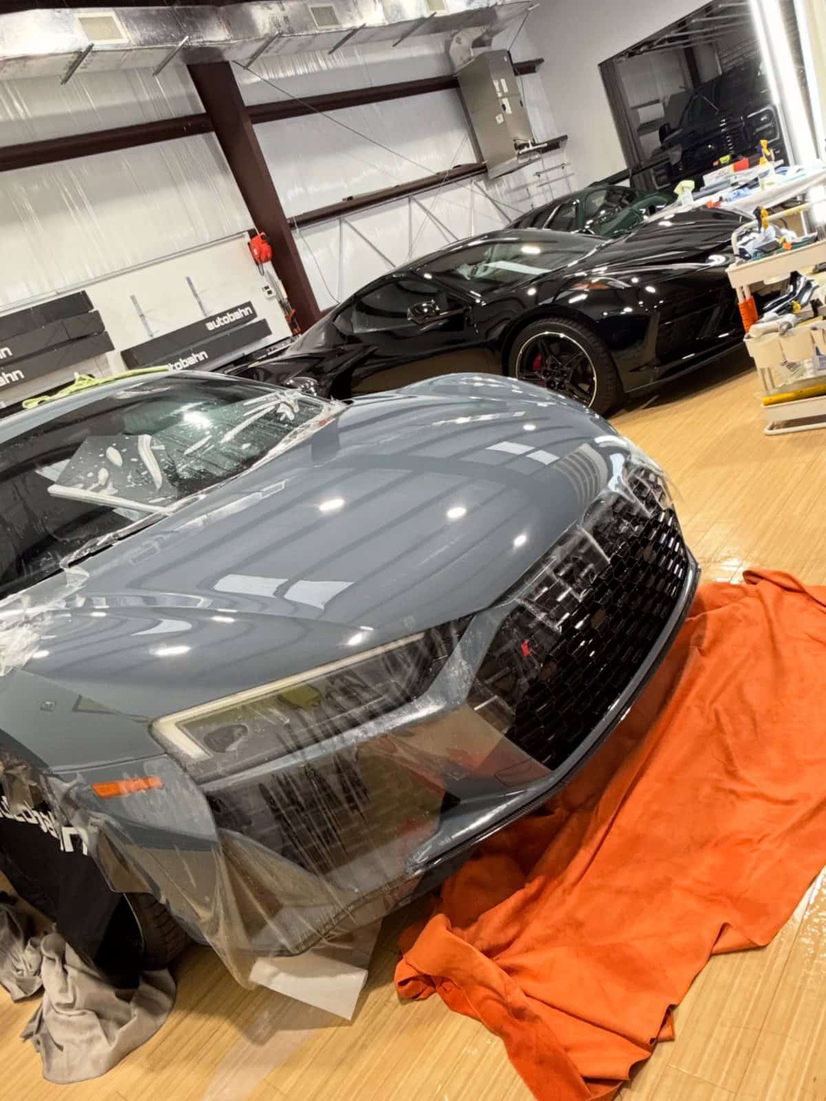Audi R8 under Autobahn Rüstung film mid-install, another car waiting behind it