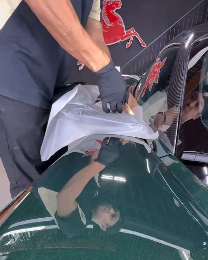 Gloved hands cutting a sheet of Autobahn film on the Valhalla's bodywork