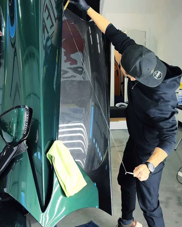 An installer working film along the Valhalla's raised carbon door